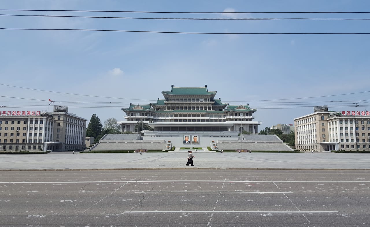 A well-timed photo of two synchronized women walking by the Grand People's Study House.