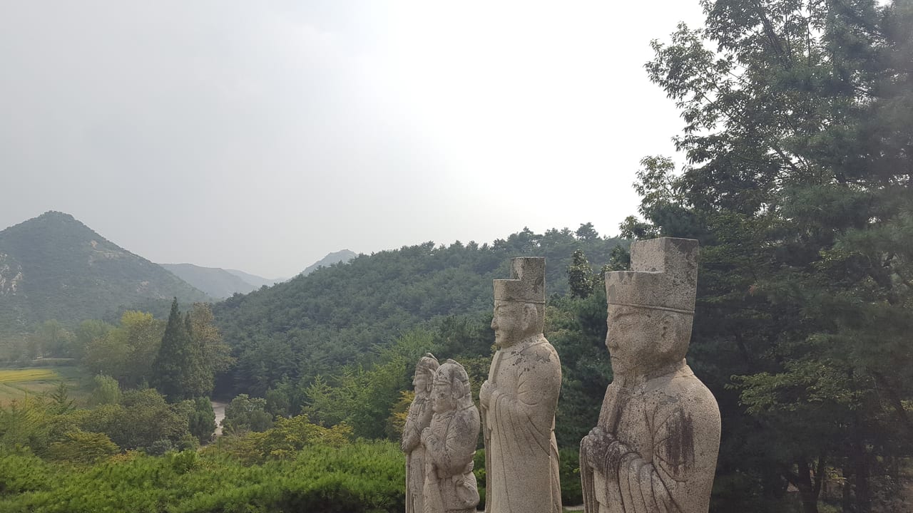 A further row of statues with the hilly backdrop.