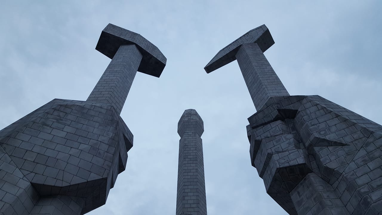 Looking up to the hammer, sickle, and brush of the monument.